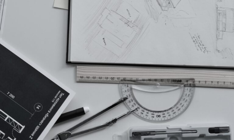 Architectural sketch with ruler, protractor, and drafting tools on a workspace